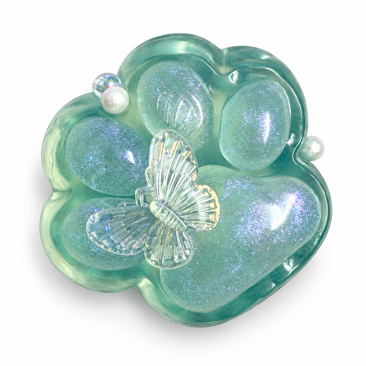 Pale teal glitter paw squishy with a clear butterfly and pearl beads